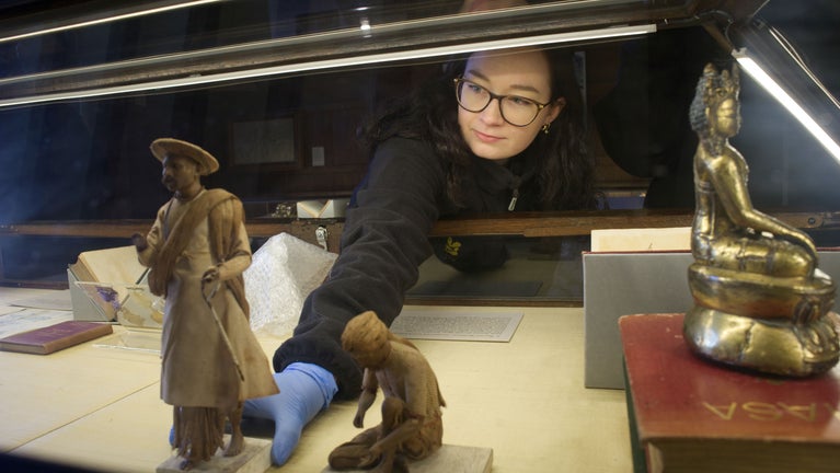 A person arranging a display case at Bateman's